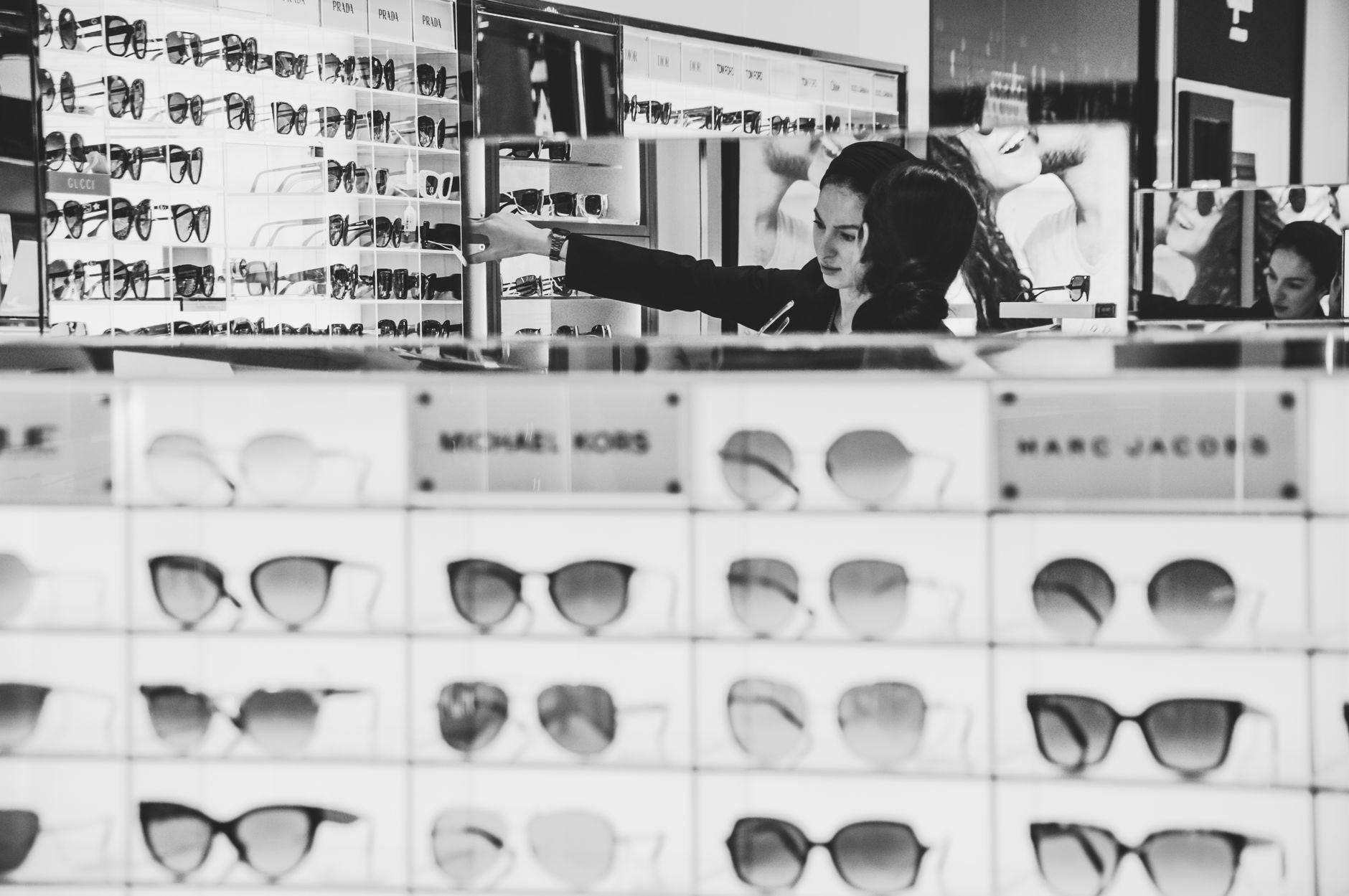 Stylish eyewear shopping with a focus on designer brands in a modern store.