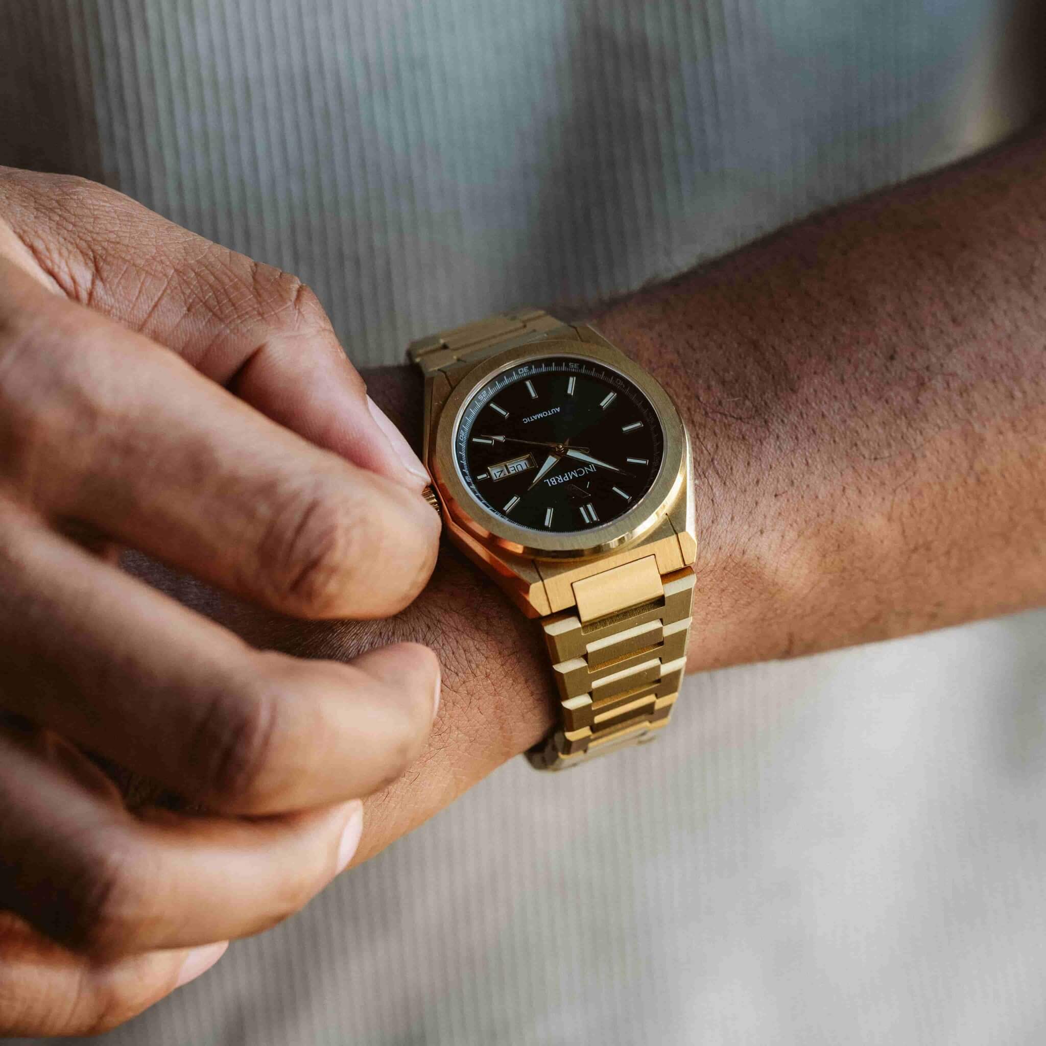 Gold watch on a wrist with a blurred background