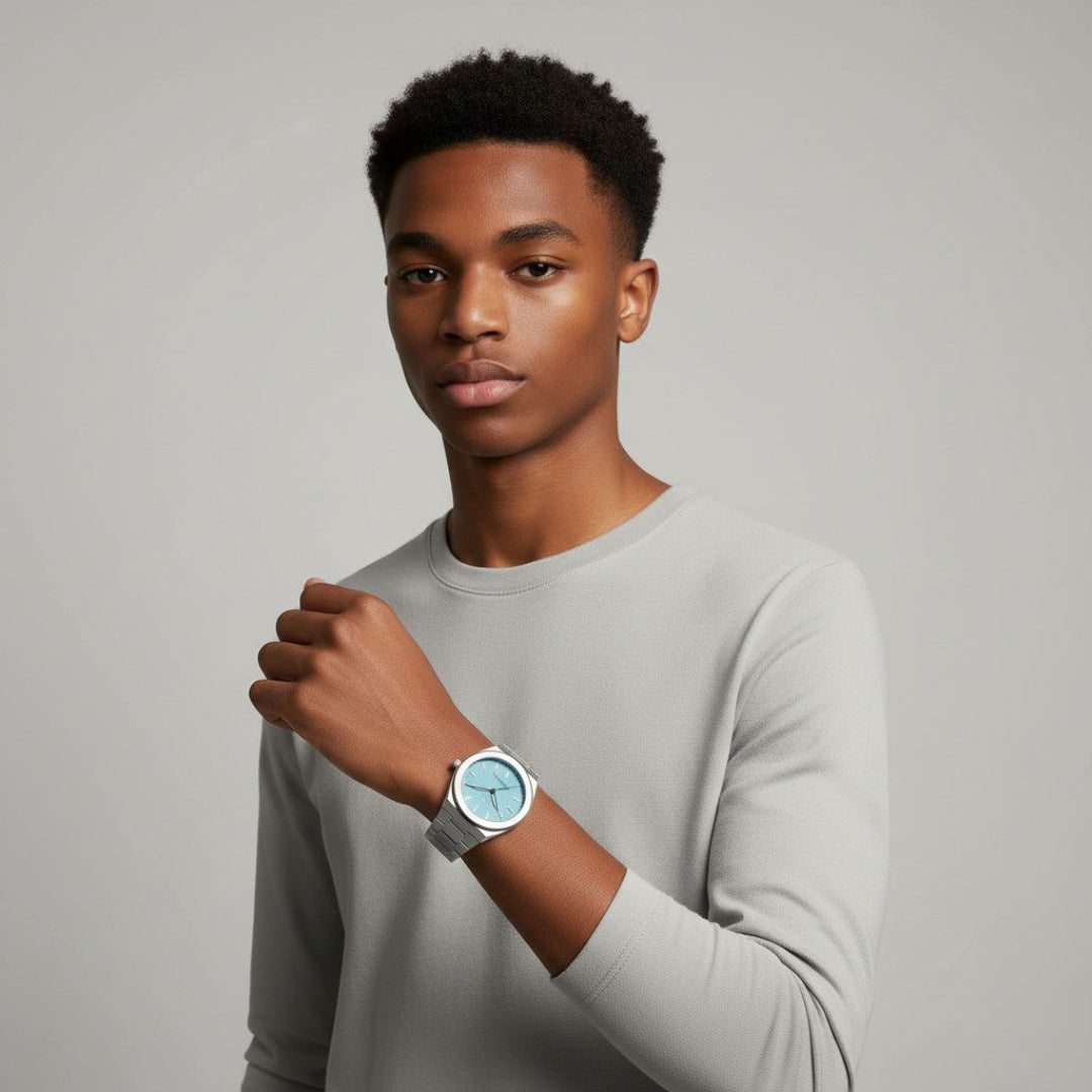 Man wearing a light gray long-sleeve shirt and a watch on a plain background