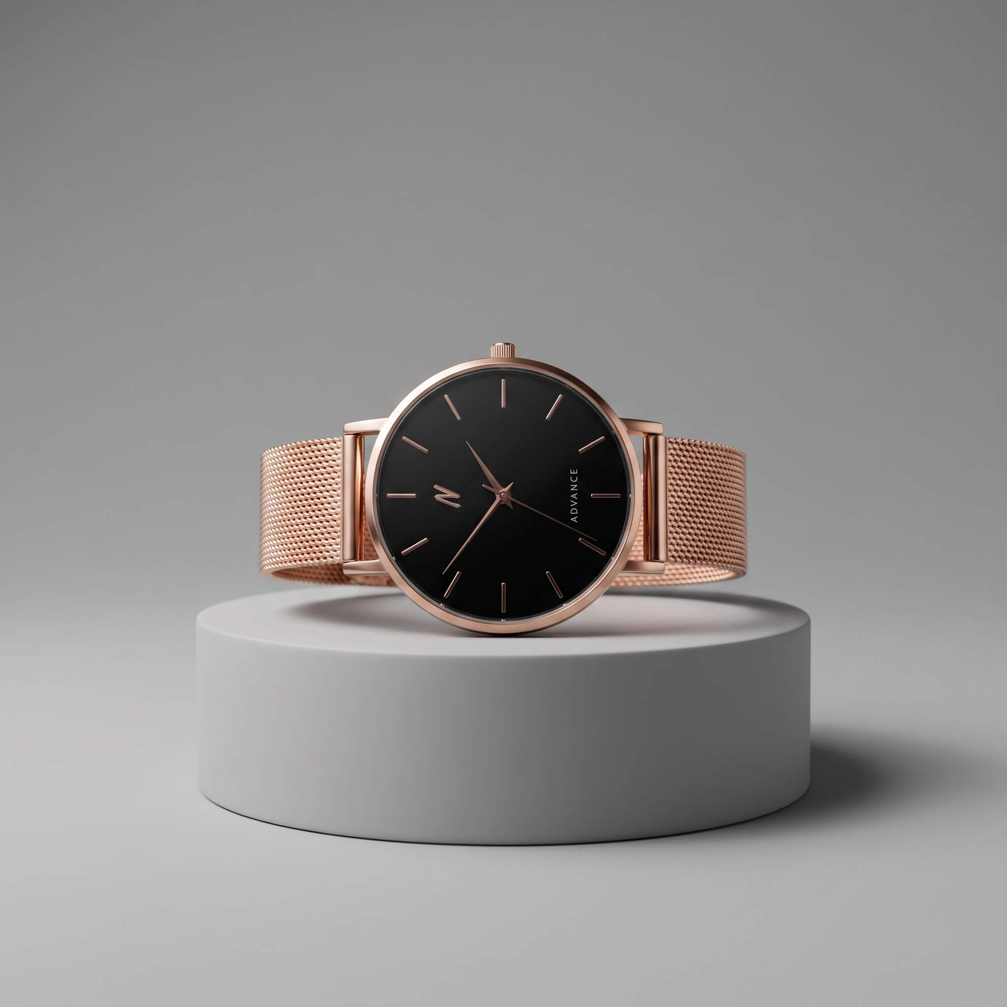 A NCMPRBL wristwatch with a rose gold mesh band and a black dial, displayed on a round gray pedestal against a neutral gray background. Advance CRWN 36MM