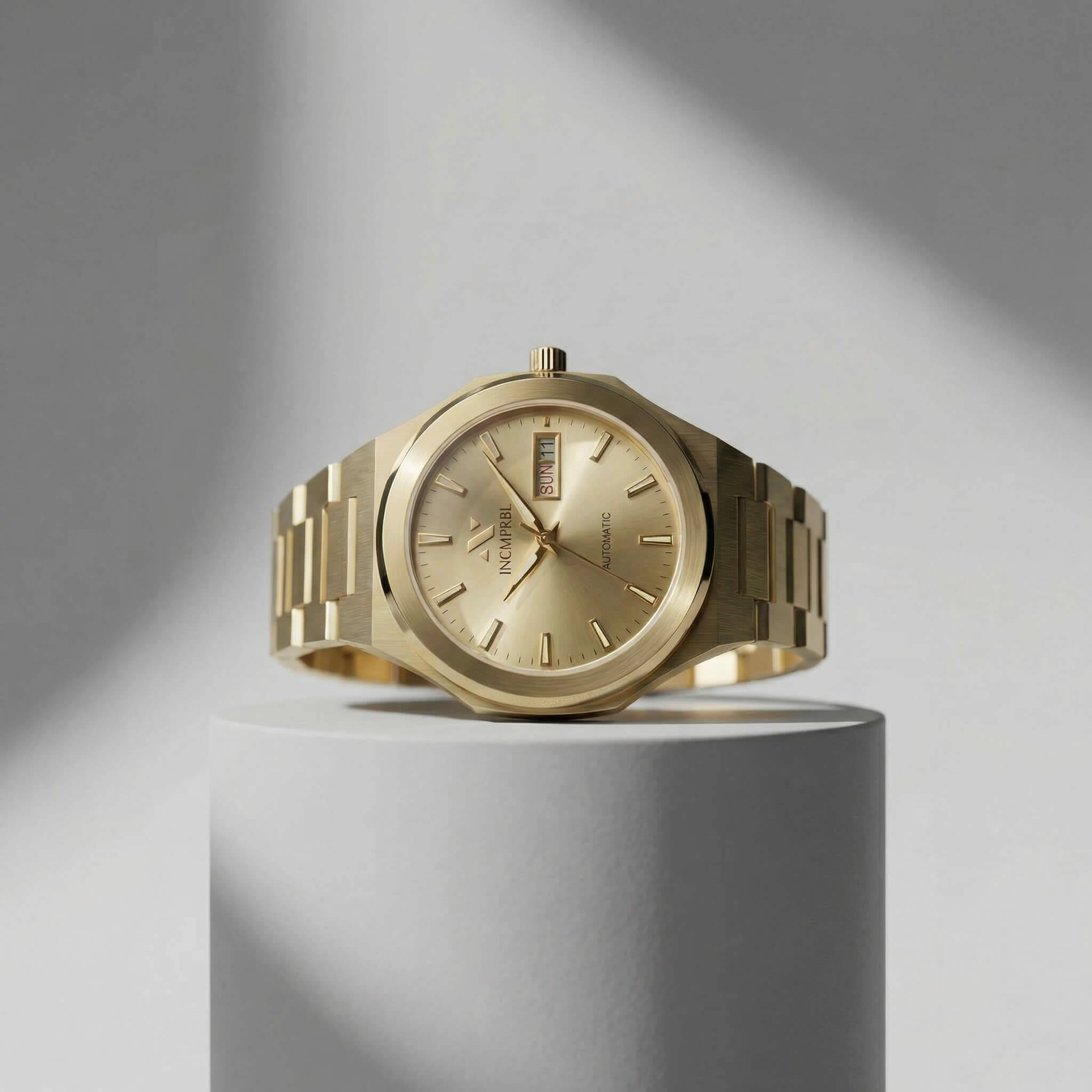 ascend aurel 36mm automatic link Gold watch on a gray cylindrical stand with a gray background