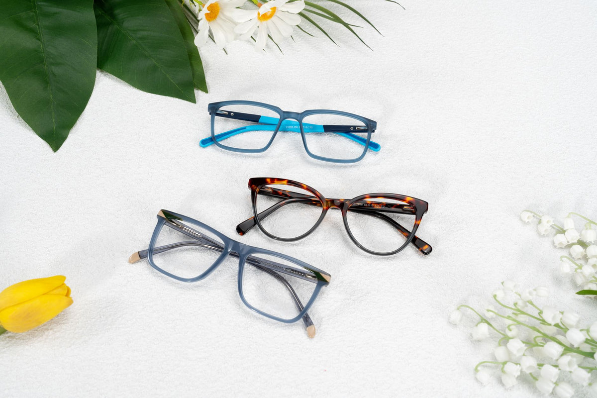 Stylish glasses arranged with spring flowers on a textured background. Modern and chic.
