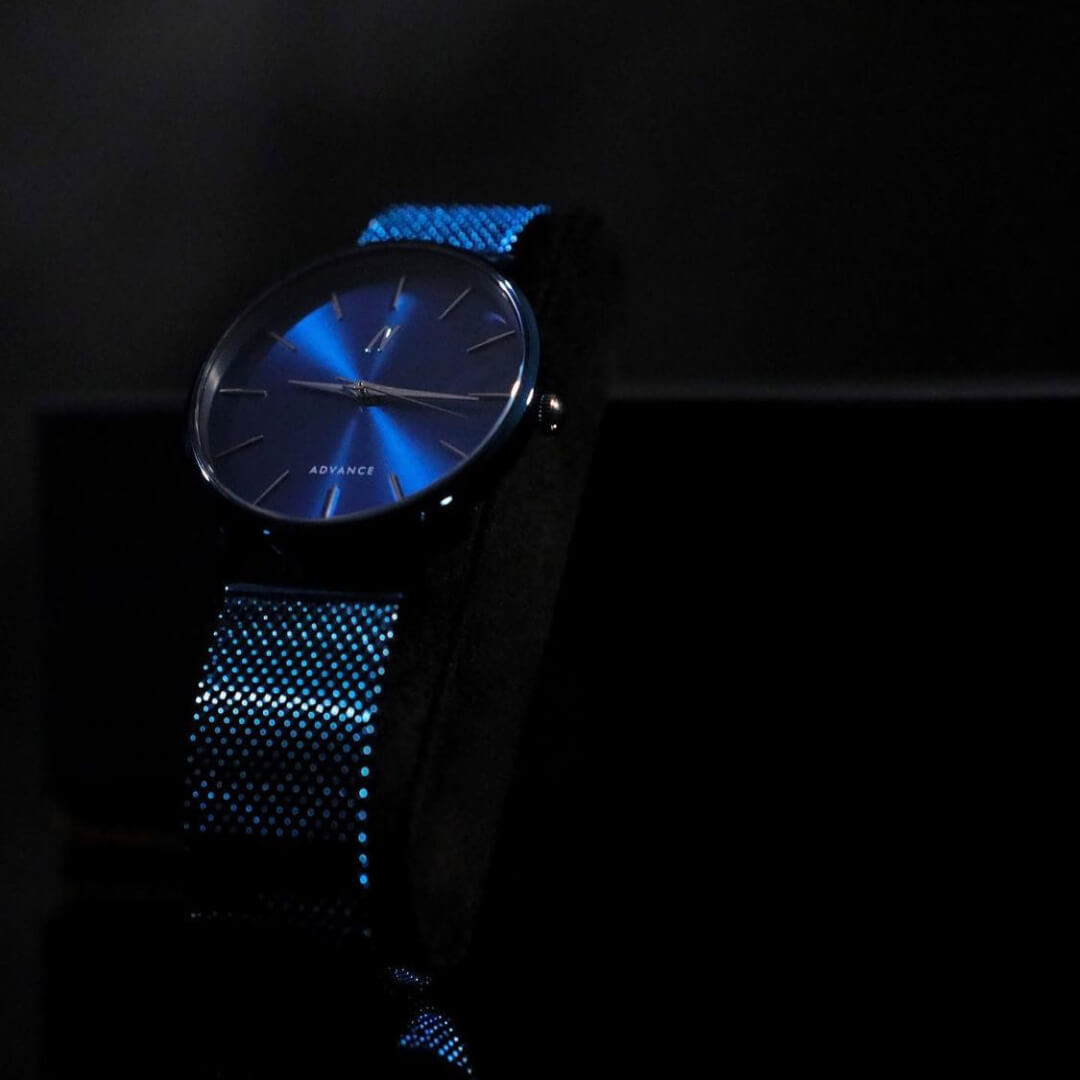 Advance Midnight Blue Quartz Unisex watch 36MM on black stand with blue sunburst dial and mesh strap